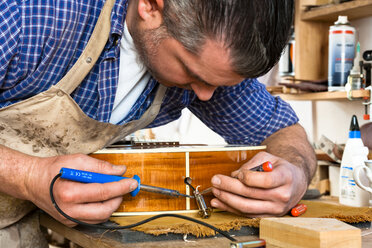 Gitarrenbauer in seiner Werkstatt - TC003900