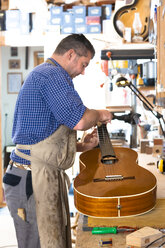 Gitarrenbauer in seiner Werkstatt - TC003888