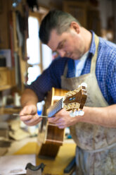 Gitarrenbauer in seiner Werkstatt - TC003892