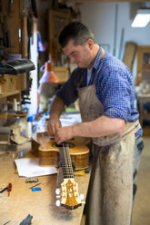 Guitar maker in his workshop - TC003886