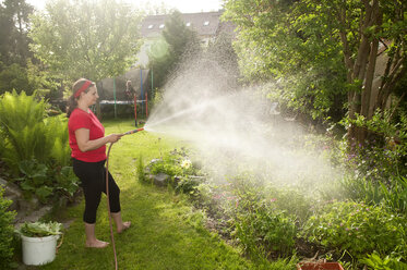 Frau im Garten, die Pflanzen gießt - BFRF000339