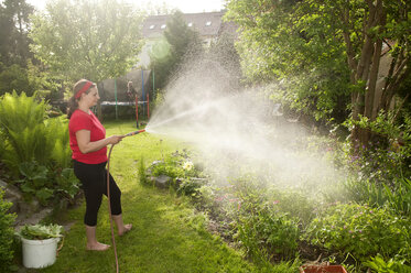 Woman in garden watering plants - BFRF000339