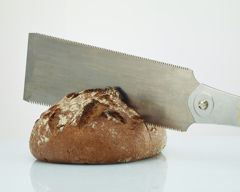 Brot mit der Säge teilen, lizenzfreies Stockfoto