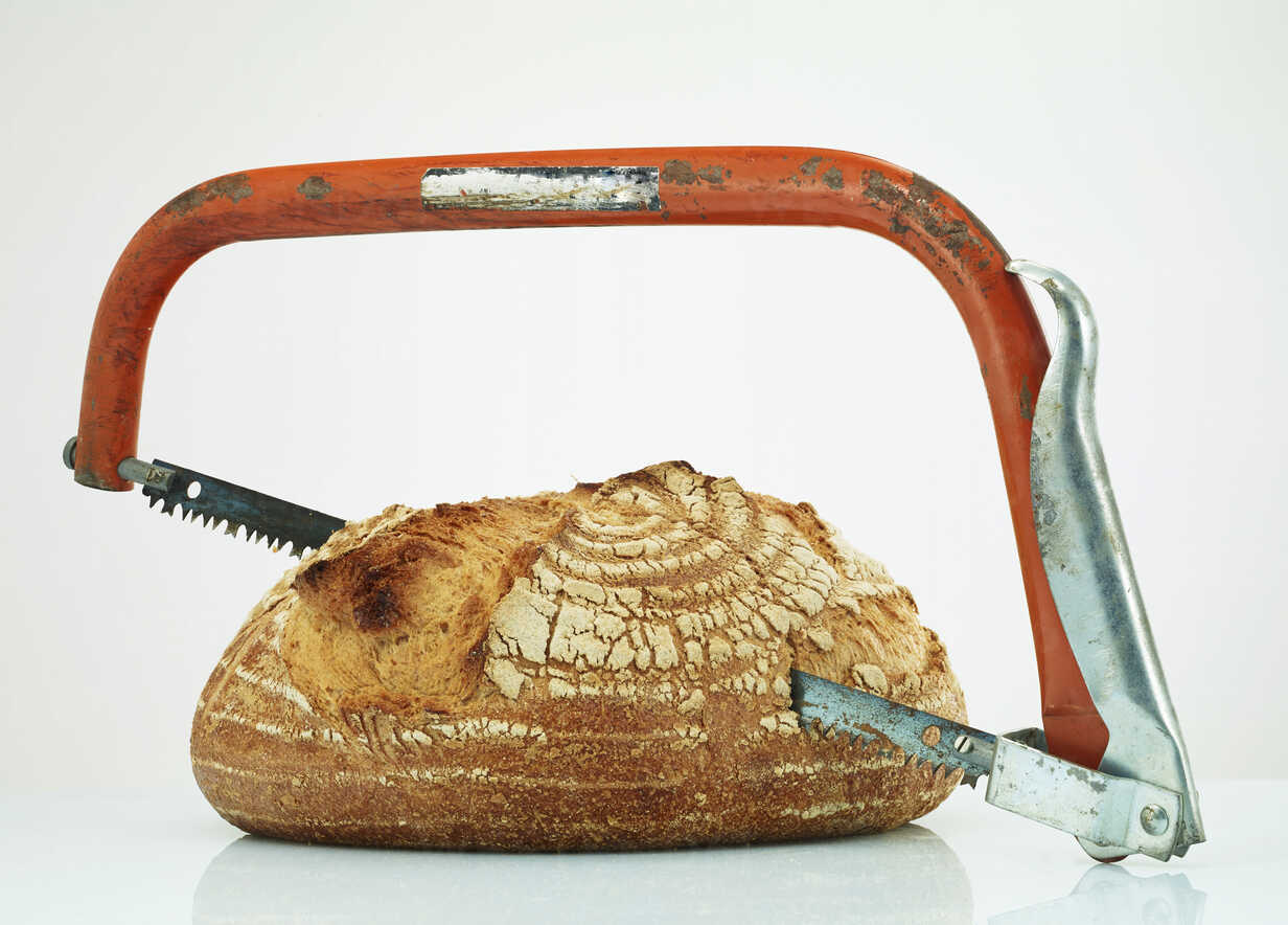 Sharing loaf of bread with saw stock photo