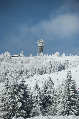 Deutschland, Baden-Württemberg, Schwarzwald, Feldberg, Feldbergturm und Skipiste im Winter, lizenzfreies Stockfoto