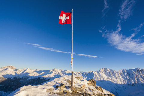 Schweiz, Graubünden, Savognin, Berggipfel Piz Martegnas, Schweizer Flagge, lizenzfreies Stockfoto
