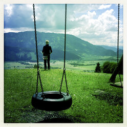 Woman looking into the valley, swing in the foreground, Enns, Styria, Austria - DISF000502