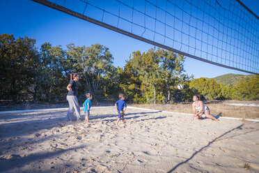 USA, Texas, Zwei junge Frauen und zwei Jungen spielen Beachvolleyball - ABAF001209