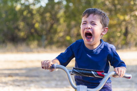 USA, Texas, Verzweifelter Junge auf Fahrrad, lizenzfreies Stockfoto