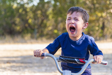 USA, Texas, Verzweifelter Junge auf Fahrrad - ABAF001206