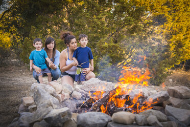 USA, Texas, Two young women and two boys at camp fire - ABAF001203