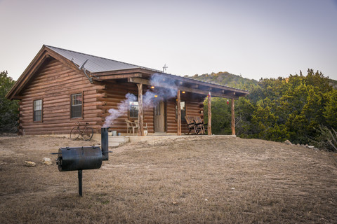 USA, Texas, Blockhaus mit Barbecue-Smoker vor dem Haus, lizenzfreies Stockfoto