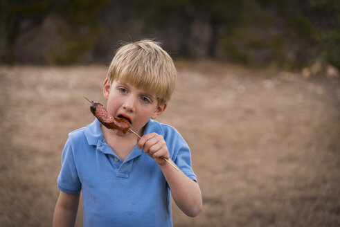 USA, Texas, Junge isst Grillwurst - ABAF001198