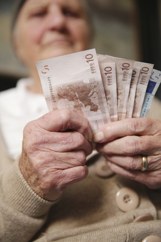 Senior woman holding euro notes stock photo