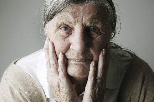 Porträt einer älteren Frau mit dem Kopf in ihren Händen - JATF000637