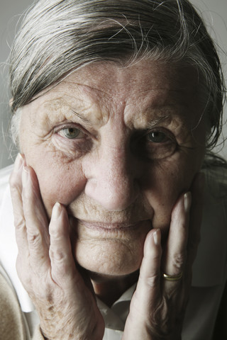 Porträt einer älteren Frau mit dem Kopf in ihren Händen, lizenzfreies Stockfoto