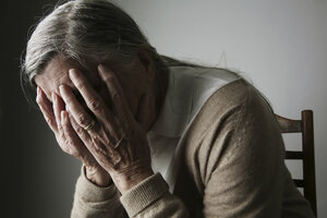 Ältere Frau bedeckt ihr Gesicht mit den Händen - JATF000651