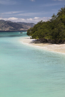 Indonesien, Blick auf Lombok von der Insel Gili Air, traditionelles Holzboot am Strand - KRP000219