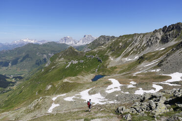 Schweiz, Graubünden, Ratikon, Grfiersee mit Drei Türmen und Sulzfluhbergen im Hintergrund, Wanderer an der österreichischen Grenze - SIE005033