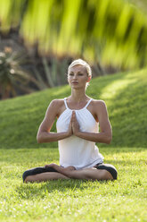 Woman practicing yoga on meadow - EGF000114