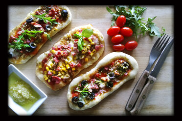 Pizzabrötchen, belegt mit Tomate, Mozzarella, Rucola, Mais, Salami, Schinken, Oliven, Studio - MAEF007716