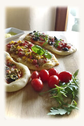 Pizzabrötchen, belegt mit Tomate, Mozzarella, Rucola, Mais, Salami, Schinken, Oliven, Studio - MAEF007711