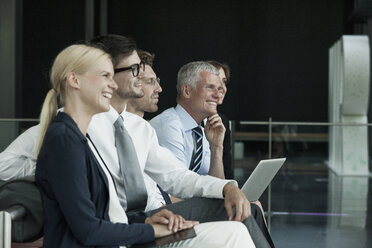 Group of smiling businesspeople with laptop - CHAF000067