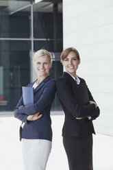 Zwei selbstbewusste Geschäftsfrauen vor einem Bürogebäude - CHAF000053