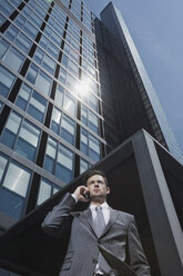 Businessman on cell phone outside office building - CHAF000081