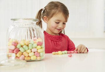 Deutschland, München, Mädchen mit Bonbonglas, Bonbons zählend - FSF000162