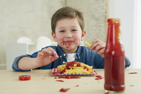 Germany, Munich, Boy eating French fries with ketchup - FSF000192