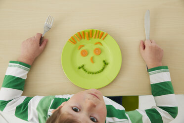 Germany, Munich , Boy eating peas and carrots showing anthropomorphic face - FSF000187