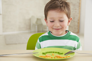 Germany, Munich , Boy eating peas and carrots showing anthropomorphic face - FSF000152