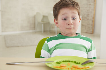 Germany, Munich , Boy eating peas and carrots showing anthropomorphic face - FSF000149