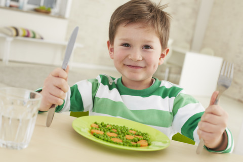 Germany, Munich , Boy eating peas and carrots stock photo