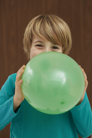 Deutschland, Junge bläst Luftballon auf, lizenzfreies Stockfoto