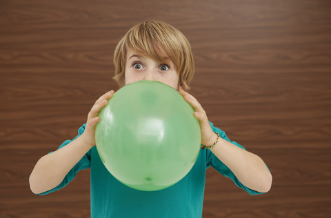 Germany, Boy inflatiing balloon stock photo