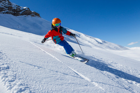 Schweiz, Graubünden, Obersaxen, Jungenskifahren, lizenzfreies Stockfoto