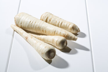 Four parsley roots on white wooden table - MAEF007734