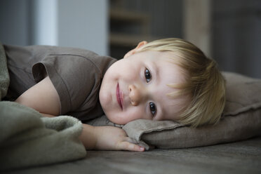 Lächelndes kleines Mädchen auf Kissen liegend, Porträt - FKF000401