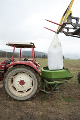 Germany, Rhineland-Palatinate, Neuwied, artificial fertilizer filling into tractor - PA000363