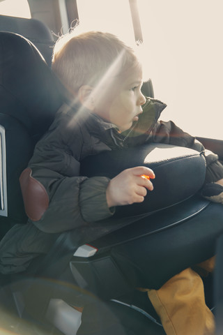 Deutschland, Kleiner Junge auf dem Rücksitz eines Autos, lizenzfreies Stockfoto