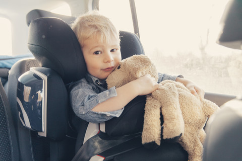 Germany, Little boy sitting in back-seat car seat stock photo