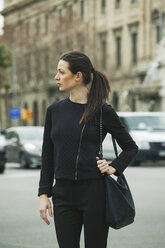 Spain, Catalunya, Barcelona, young black dressed businesswoman walking along a street - EBSF000002