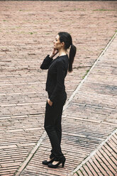 Spain, Catalunya, Barcelona, young black dressed businesswoman telephoning on a square - EBSF000016