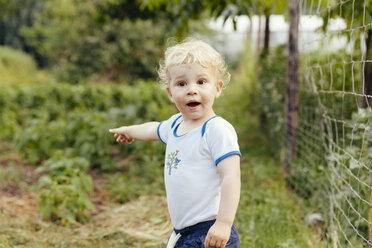 Toddler pointing at something in vegetable garden - MFF000876
