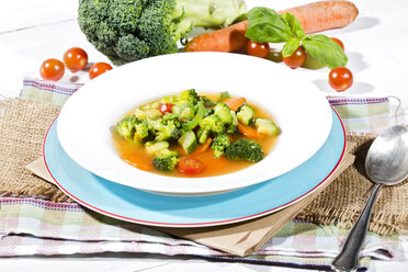Vegetable soup with broccoli, tomato, spring onion, zucchini, tomato paste and carrot, close-up - MAEF007757