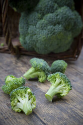 Brokkoliröschen und Brokkoli (Brassica oleracea var. italica) auf Holztisch - LVF000605