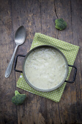 Cooking pot of broccoli soup, cloth and spoon on wooden table - LVF000598