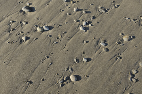 Kieselsteine am nassen Sandstrand, Teilansicht - RUEF001166